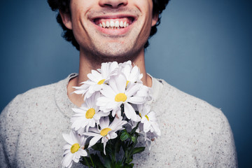 Happy young man with flowers