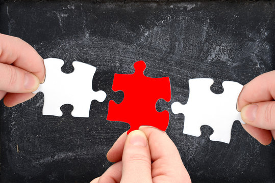 Drei Puzzleteile und Tafel mit Finger