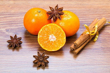 Orange fruit, cinnamon sticks and anise stars on wooden table