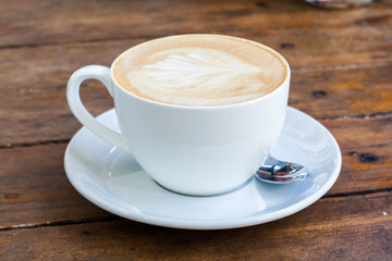Latte art coffee over wooden background