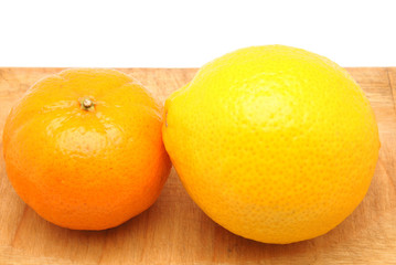 lemon and mandarin orange on a cutting board