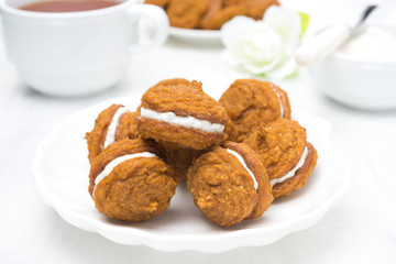 Pumpkin cookies with cream filling and tea