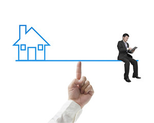 Businessman sitting on seesaw balance with home
