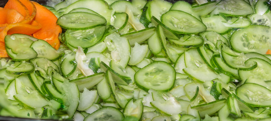 Appetizing green cucumbers salad with carrot