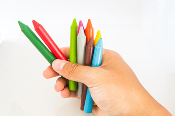 Hand holding colored vax pencil