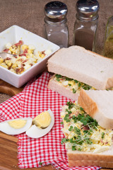 Fresh egg and bacn on white sandwich in rustic kitchen setting