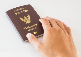 Hand holding an Thailand passport isolated on white background