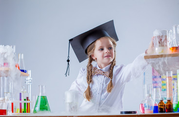 Adorable little girl conducting experiment in lab