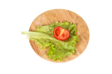 Half of tomato and lettuce on a cutting board top view