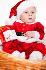 little santa baby with christmas hat lying in basket