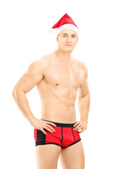 Guy with santa hat wearing underpants and looking at camera