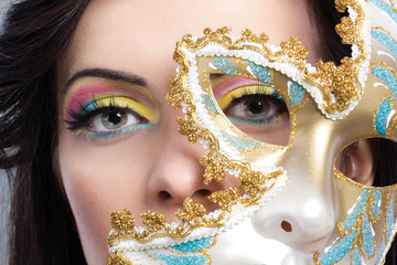 beautiful young woman with mysterious venetian mask close up