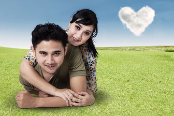 Young Couple Lying On Green Grass