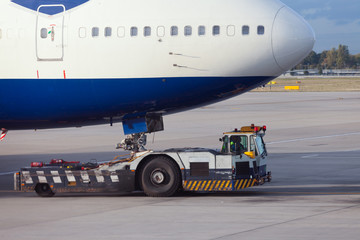 Aircraft tug towing big airliner to dock position
