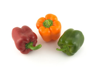 Three whole color ripe bell peppers isolated on white close up