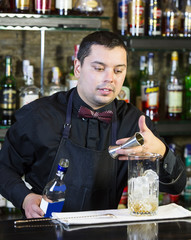 young man working as a bartender in a nightclub bar