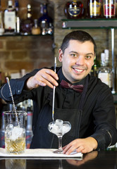young man working as a bartender in a nightclub bar