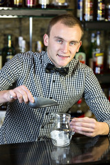 young man working as a bartender in a nightclub bar