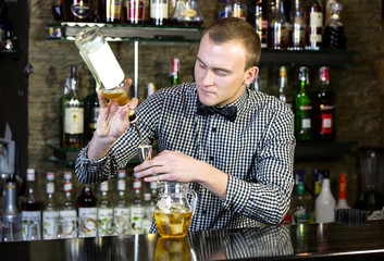 young man working as a bartender in a nightclub bar