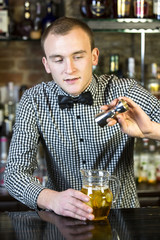 young man working as a bartender in a nightclub bar