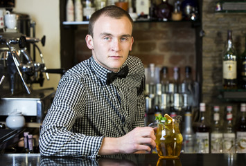 young man working as a bartender in a nightclub bar
