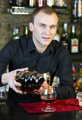 young man working as a bartender in a nightclub bar