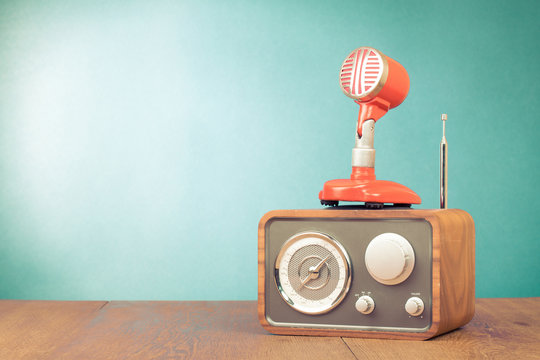 Retro radio, red microphone, headphones on table old style photo