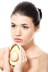 Beautiful spa woman holding avocado.