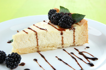 Slice of cheesecake with chocolate sauce and blackberry