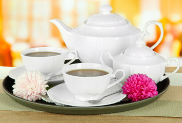 Obraz na płótnie Canvas Cups of tea on tray on table in cafe