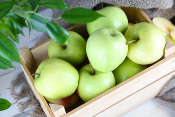 Juicy apples in box on wooden table