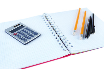 Notebook with pens,pencils and calculator isolated on white