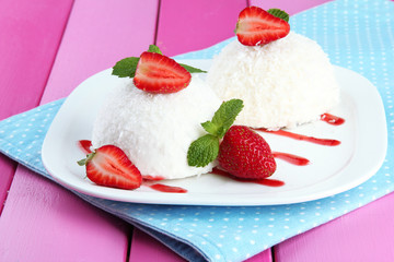 Delicious coconut cakes on plate on table close-up