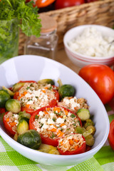 Stuffed tomatoes in bowl on wooden table close-up