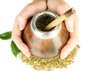 Woman hands holding calabash and bombilla with yerba mate
