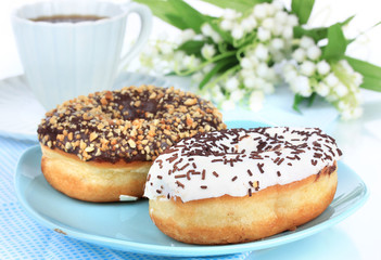 Fototapeta na wymiar Sweet donuts with cup of tea on table close-up
