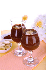 Cocktails with banana and chocolate on table on white