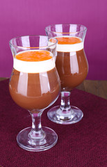 Dessert of chocolate and persimmon on table on purple