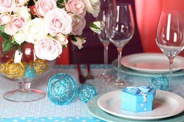 Table serving with colorful tableware on room background