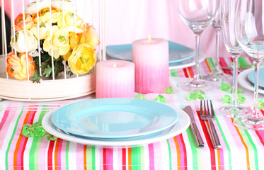 Table serving with colorful tableware on room background