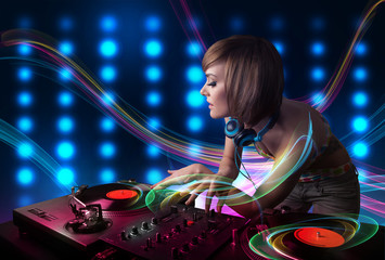 Young Dj girl mixing records with colorful lights