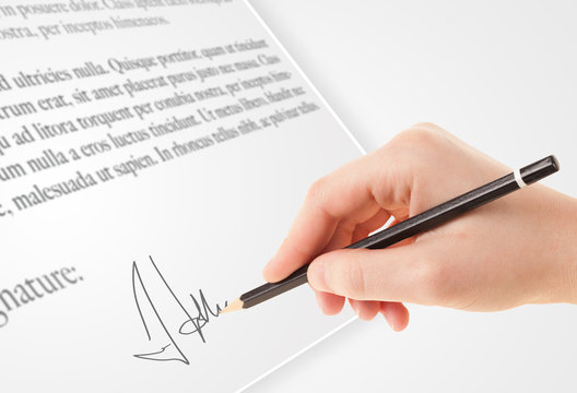 Hand writing personal signature on a paper form