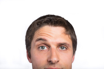 Close-up of a green eyed man raising eyebrow
