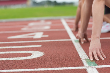 Cropped people ready to race on track field