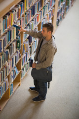 Student taking a book from shelf in library