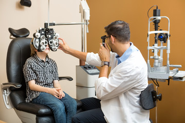 Optometrist Examining Preadolescent Boy's Eyes