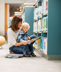 Student With Teacher Reading Book In Library