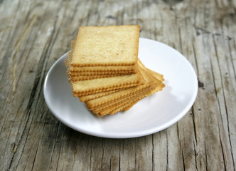 square crackers in white plate on wooden