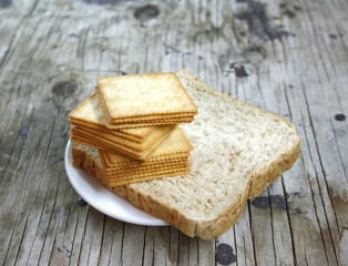 square crackers in white plate on wooden