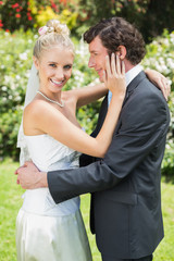 Happy wife touching her new husbands cheek smiling at camera